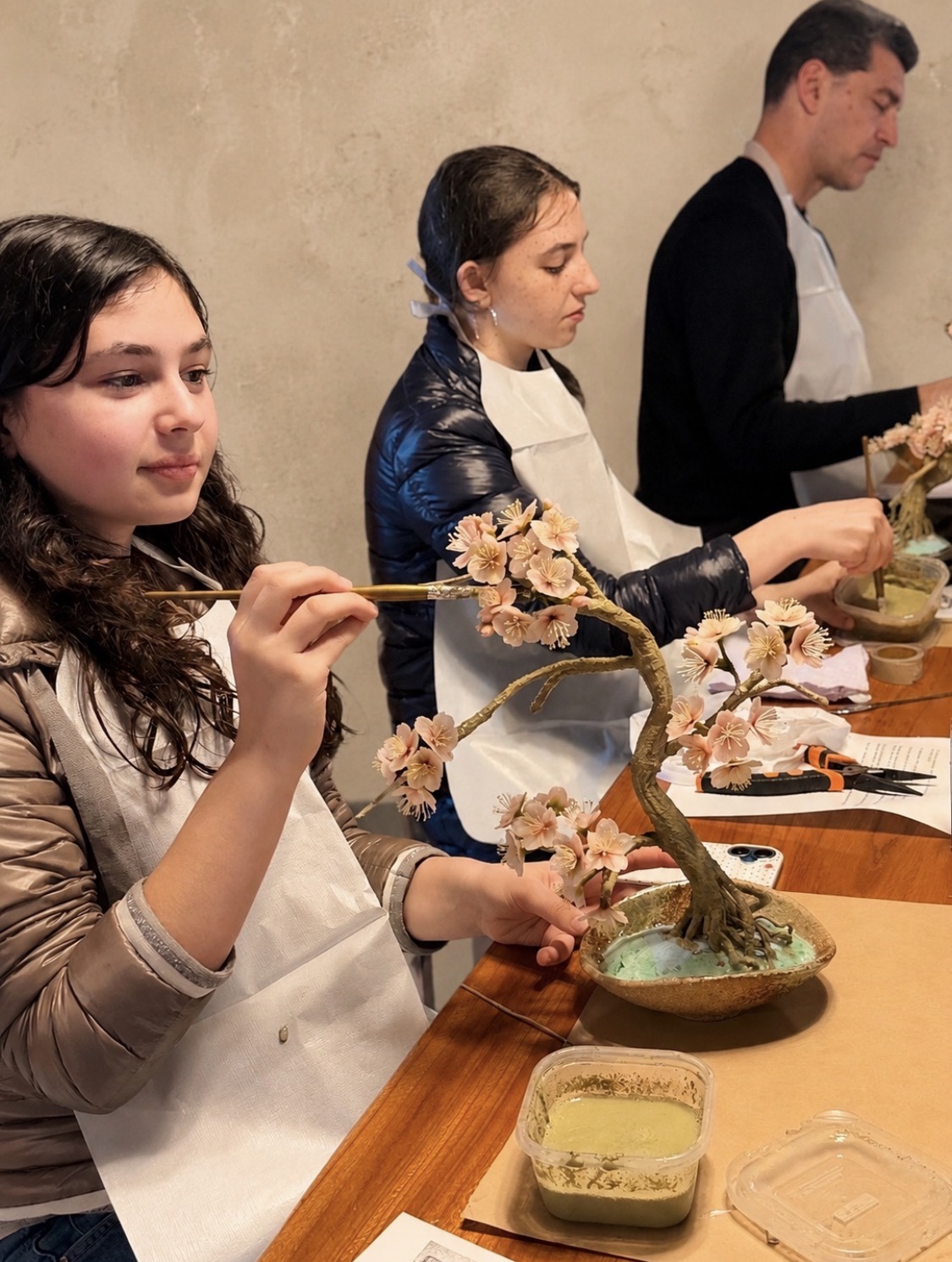 工房の作業台で制作中のアート盆栽と職人の手元